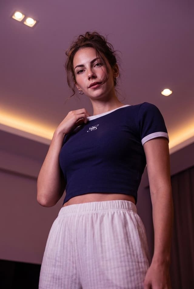 Low-angle stylized portrait of a young woman in a dim room — output
