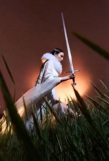 Model Climbing Slope Behind Grasses — cover